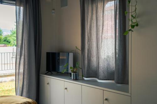 a tv sitting on top of a dresser next to a window at Dimora al Glicine in Sernaglia della Battaglia