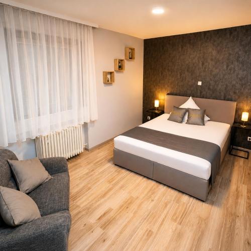 a bedroom with a large bed and a couch at Parkhotel Lindenhof - KOSTENLOSE PARKPLÄTZE in Offenbach