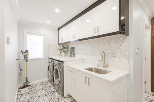 a kitchen with a sink and a washing machine at Cozy Queen Room in Quiet Richmond Seafair Area in Richmond