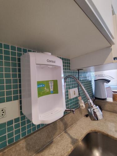 a kitchen sink with a cereal dispenser on the wall at 8 Apartamentos em Condomínio Fechado c/portaria presencial 24 hs à Beira mar na Praia do Tombo no Guarujá in Guarujá