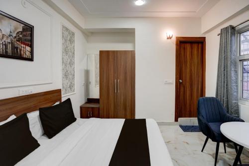 a bedroom with a bed and a table and chairs at Super Townhouse Rosens hotel in Noida
