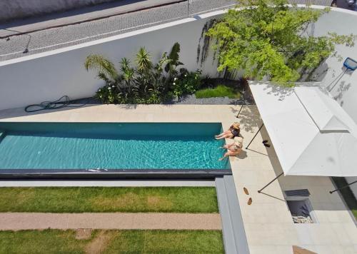 an overhead view of a swimming pool with two people standing next to it at Moderninfluence - Aparthotel in Porto