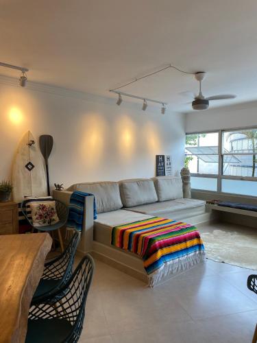a living room with a couch and a table at 8 Apartamentos em Condomínio Fechado c/portaria presencial 24 hs à Beira mar na Praia do Tombo no Guarujá in Guarujá