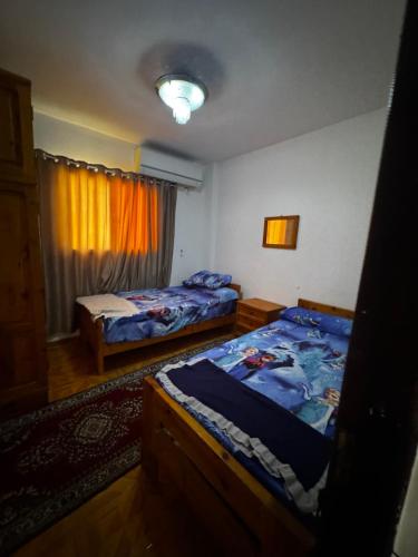 a bedroom with two beds and a window at Marseilia Resort in Al Ḩammām