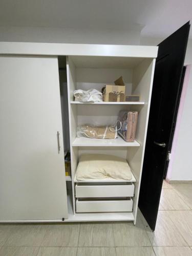 a closet with white shelves and a door at Apartment 2 in Apóstoles