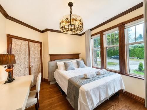 a bedroom with a bed and a desk and windows at Cozy Queen Room in Quiet Richmond Seafair Area in Richmond