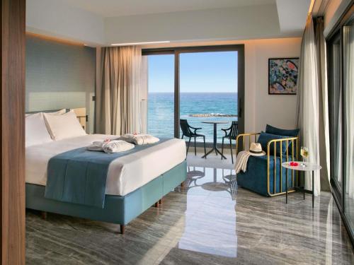 a hotel room with a bed and a view of the ocean at Mercure Larnaca Beach Resort in Larnaca