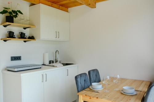 a kitchen with a wooden table and chairs at Domovi Gorjanke - Gorjanka homes in Ajdovščina
