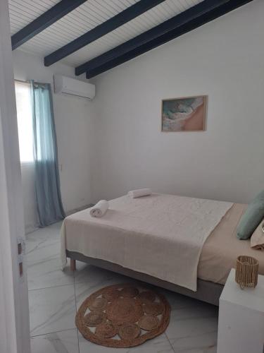 a bedroom with a bed in a white room at La Casamarie in Saint-Louis