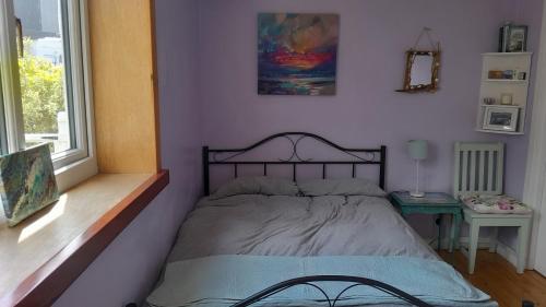 a bedroom with a bed in a room with a window at Jack's place in Balnakeil