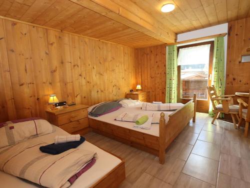 a bedroom with two beds in a wooden cabin at Bergheimat L in Huben
