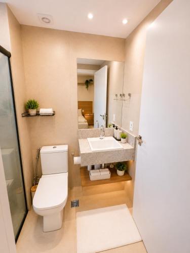 a bathroom with a toilet and a sink and a mirror at Alugueasy - EASY Noroeste in Brasília