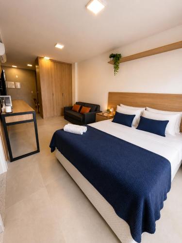 a bedroom with a large bed and a couch at Alugueasy - EASY Noroeste in Brasília