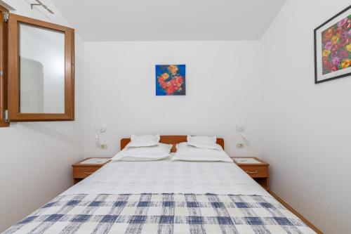 a bedroom with a bed and a mirror at Apartment Zavala 553d in Jelsa