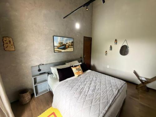 a bedroom with a bed with white sheets and pillows at Hostel Casa do Sossego in Brasília