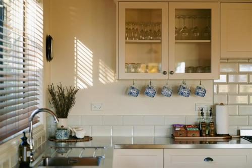a kitchen with blue and white cups and a sink at Aldourie Lodge - Lake Tekapo in Lake Tekapo