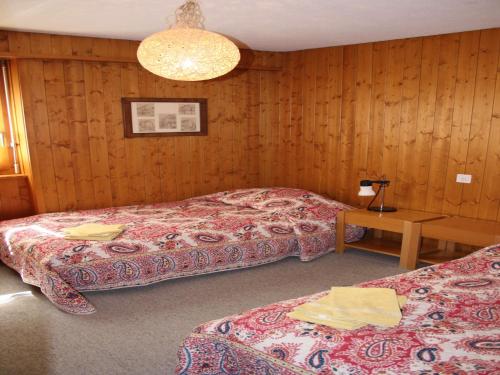 Cette chambre comprend 2 lits et une table. dans l'établissement Etoile du Sud 108, à Verbier