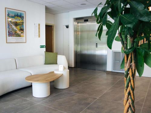 a living room with a couch and a table at Adagio Access Bordeaux Sud Pessac in Pessac