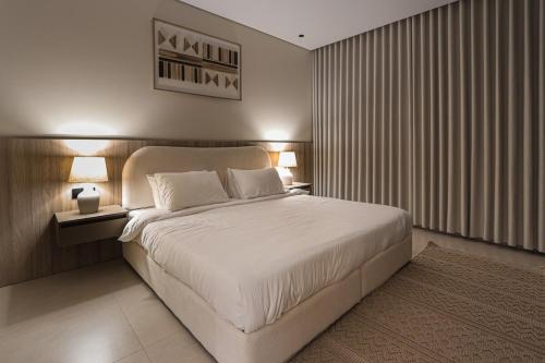 a bedroom with a large bed with two lights on at دار المصطفى in Al-Salam