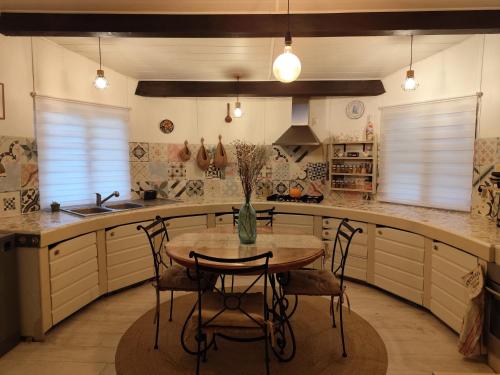 a kitchen with a wooden table and chairs in it at Teranga in Artigues