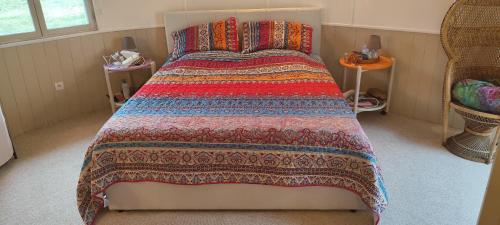 a bedroom with a large bed with a colorful blanket at Teranga in Artigues