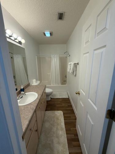a white bathroom with a sink and a toilet at House 210 Brunswick in Brunswick