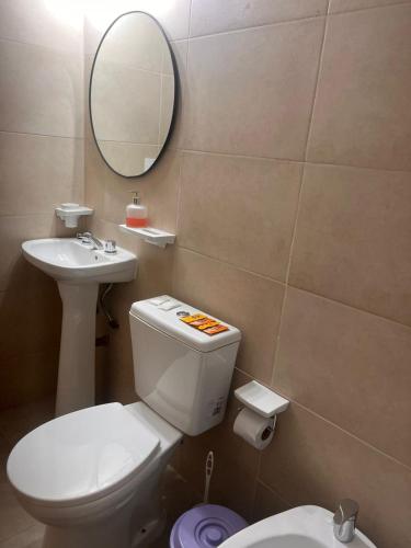 a bathroom with a toilet and a sink and a mirror at Lihuel 1 AG in Alta Gracia