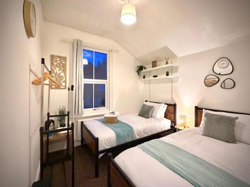 a bedroom with two beds and a window at Central Reading Guest House in Reading