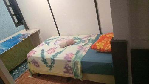a small bedroom with a bed with a colorful blanket at Chez Hinano SIKI in Bora Bora