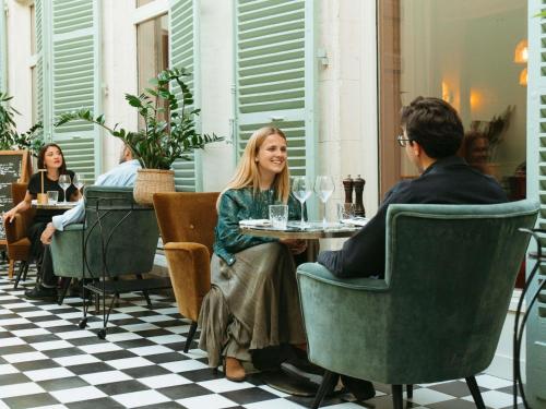 a group of people sitting at a table in a restaurant at Hotel Novotel Domaine de Maffliers - Paris Val-d'Oise in Maffliers