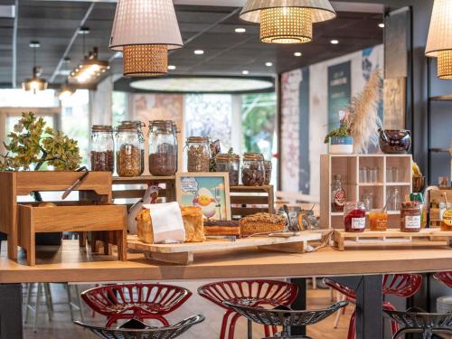 a bakery with jars of food on a counter at Hotel Novotel Evry Courcouronnes in Courcouronnes