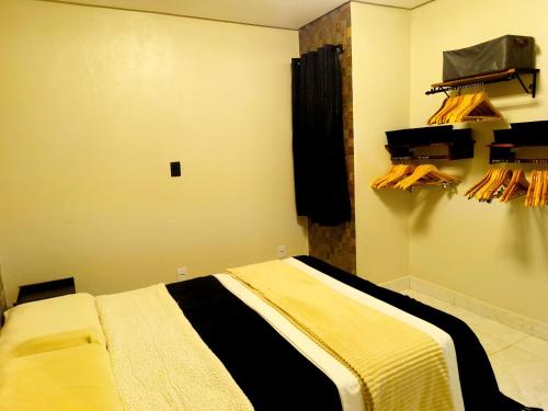 a bedroom with a bed with a black and yellow blanket at Tiny House, Refúgio Aconchegante em Mucugê in Mucugê