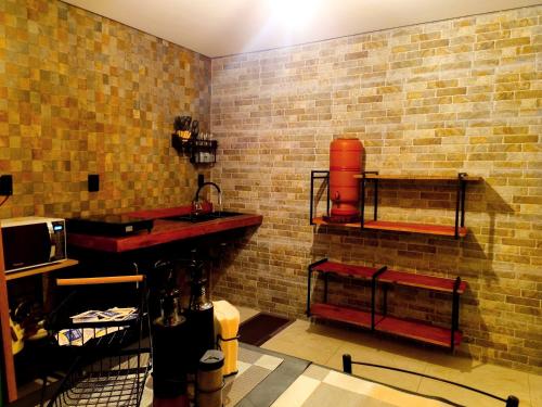 a room with a brick wall with shelves on it at Tiny House, Refúgio Aconchegante em Mucugê in Mucugê