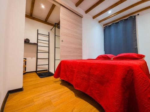 a bedroom with a bed with a red blanket at L'écrin d'Amaroa in Fort-de-France