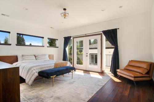 a bedroom with a bed and a chair and windows at Beautiful new home in Sanders Beach! in Coeur d'Alene