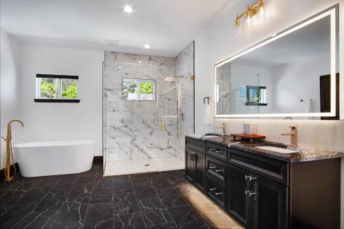 a bathroom with a tub and a sink and a shower at Beautiful new home in Sanders Beach! in Coeur d'Alene
