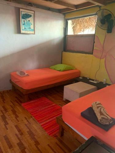 a small room with two beds and a window at Chez Hina no Pacifica in Bora Bora