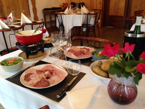 a table with plates of food and wine glasses at Les Jolis Coeurs in Thiéfosse