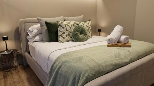 a large bed with pillows and a green blanket at Deluxe Studio in Secrt Escalante AC in San Pedro