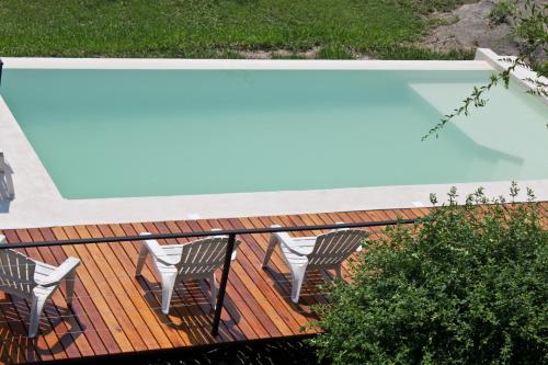 eine Terrasse mit Stühlen und einem Pool in der Unterkunft Cabañas Paititi in Villa Carlos Paz