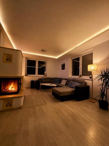 a living room with a couch and a fireplace at Bikehouse in Veľká Lomnica