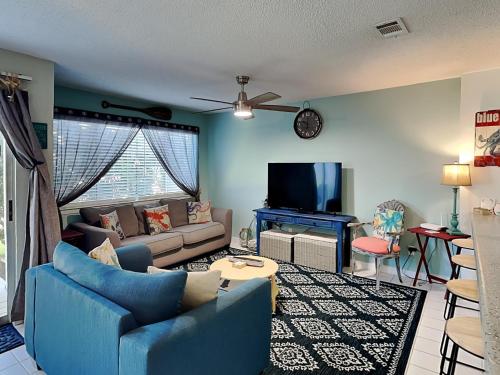 a living room with blue furniture and a flat screen tv at Island Home 102 in Destin