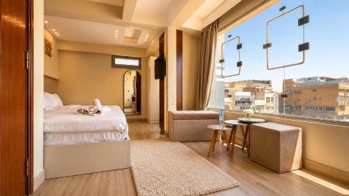 a bedroom with a bed and a large window at Queen Cleopatra Boutique Hotel in Cairo