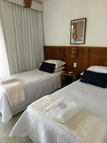 a hotel room with two beds and a mirror at Vila Anambé in Uruçuca