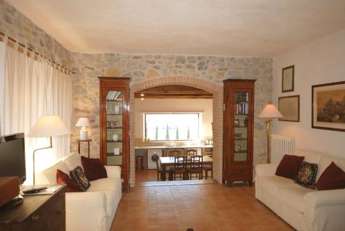 a living room with two white couches and a kitchen at Agriturismo I Gergoni in Monteleone dʼOrvieto