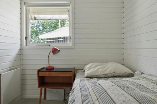 a bedroom with a bed and a table with a lamp at Experience Nature's Embrace And Peace in Græsted