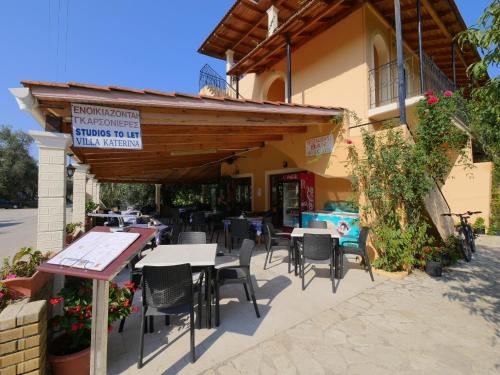 a restaurant with tables and chairs in front of a building at Villa Katerina in Agios Georgios Pagon