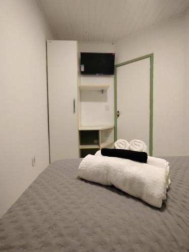 a bedroom with a bed with two towels on it at Casa Almendra in Búzios