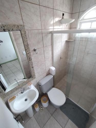 a bathroom with a sink and a toilet and a mirror at Casa Almendra in Búzios