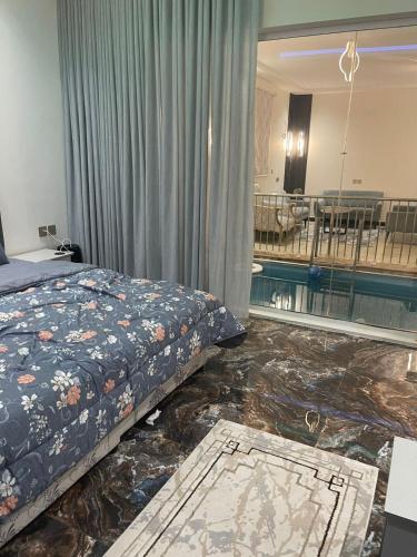 a bedroom with a bed and a swimming pool at شالية الفهد in As Sayl al Kabīr